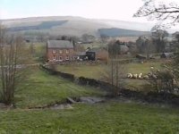 Photograph: Greenholme, the village green with its dry stone walls and sheep to the front and the Pennines to the rear.